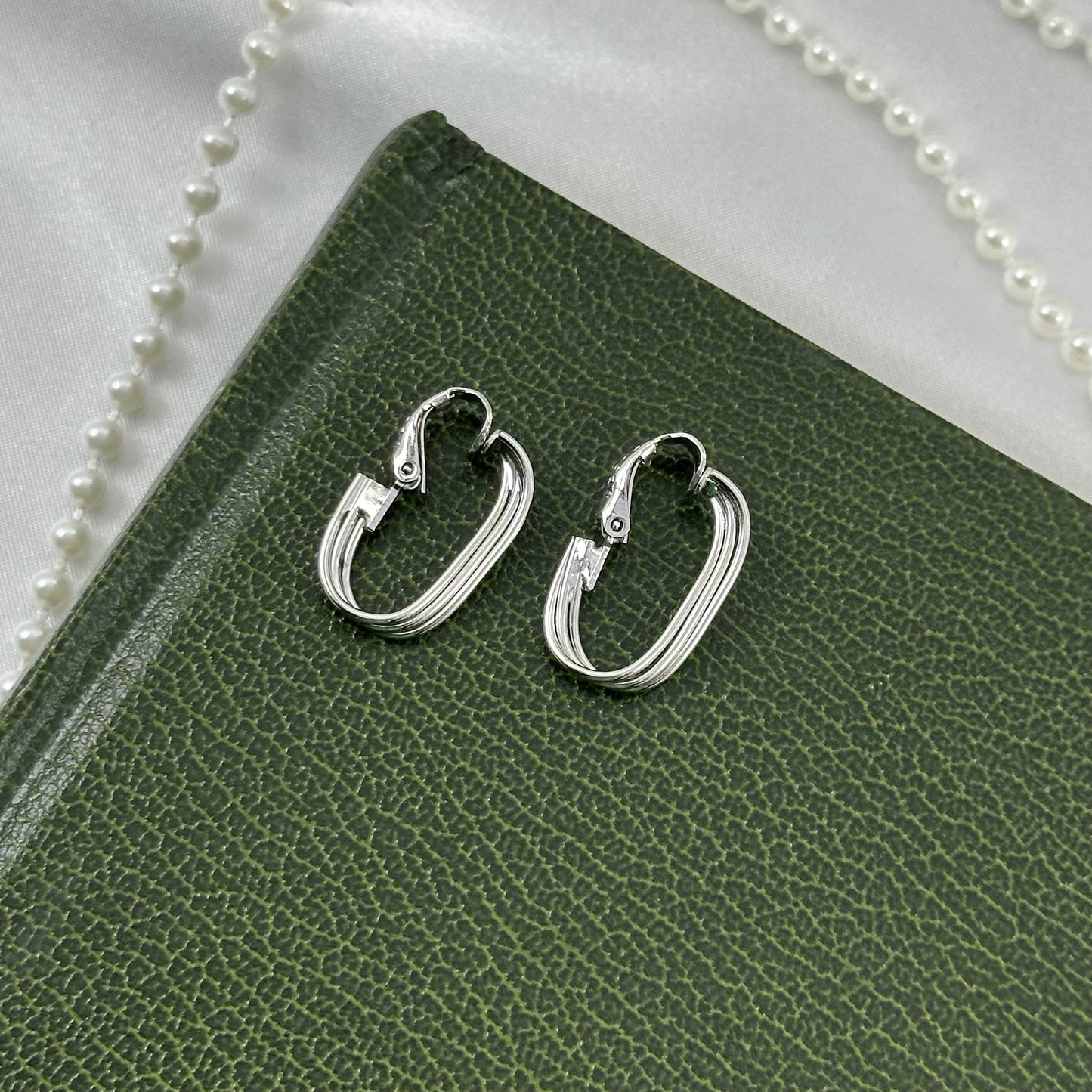 Vintage silver tone clip on hoop earrings with 3 metal bands.