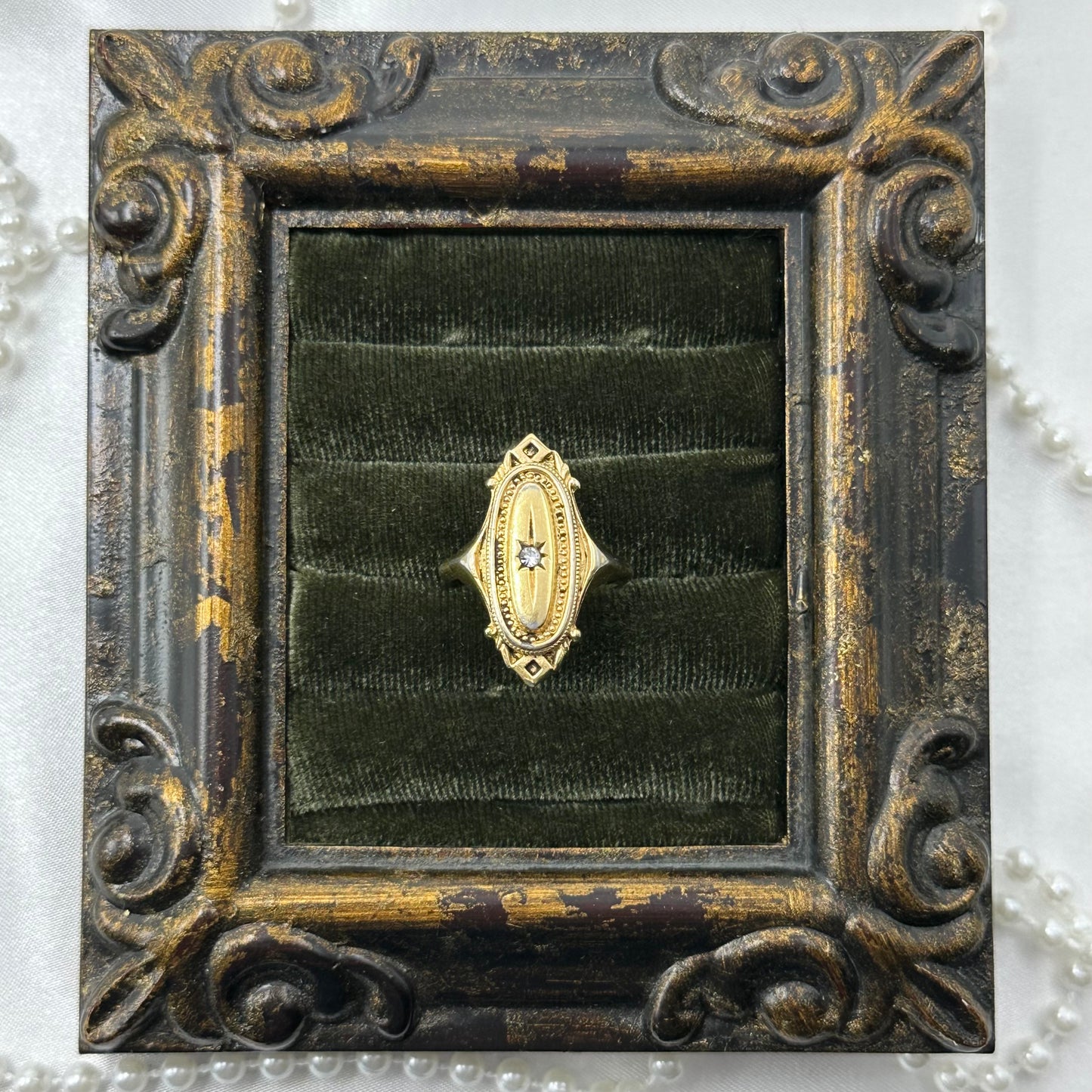Vintage gold tone Avon Kensington ring featuring an oval Victorian revival design with center star set rhinestone from 1976.
