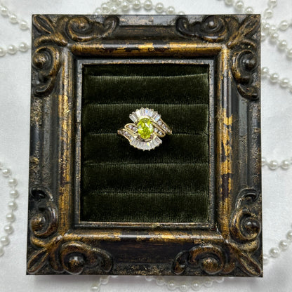 14k gold electroplated vintage art deco style deadstock ring with light green CZ center stone surrounded by clear cubic zirconia stones.