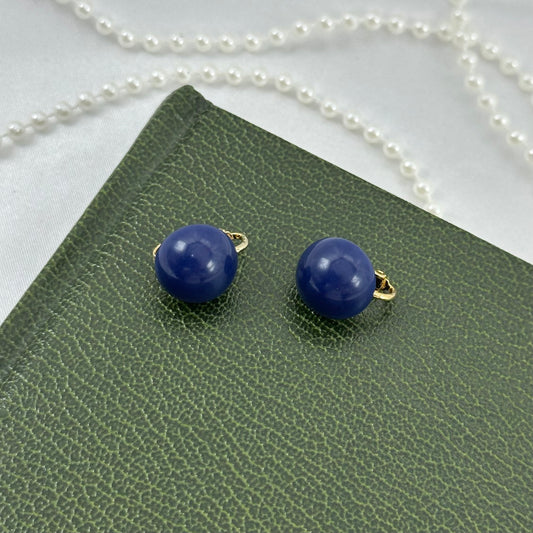 Classic vintage gold tone clip on earrings with blue buttons.