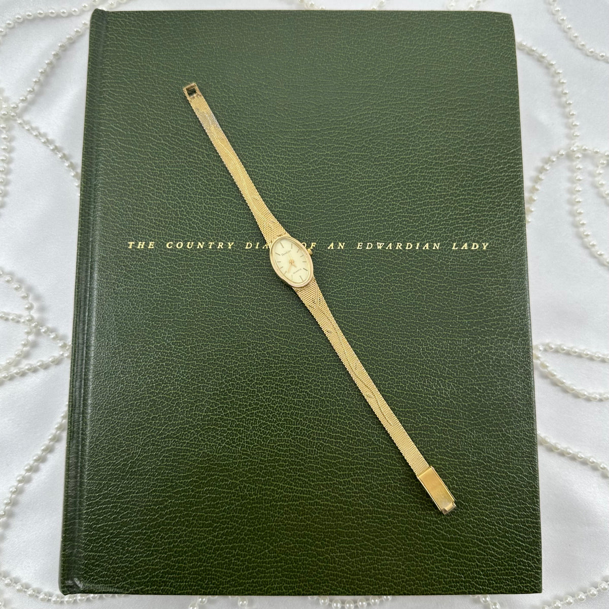 Slender Gold Armitron Watch with Oval Dial and Floral Band