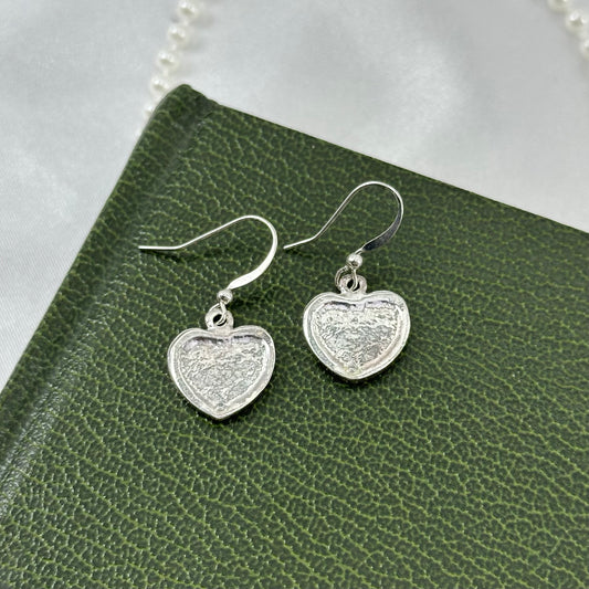 Vintage silver tone heart dangle earrings with single stone at the bottom.