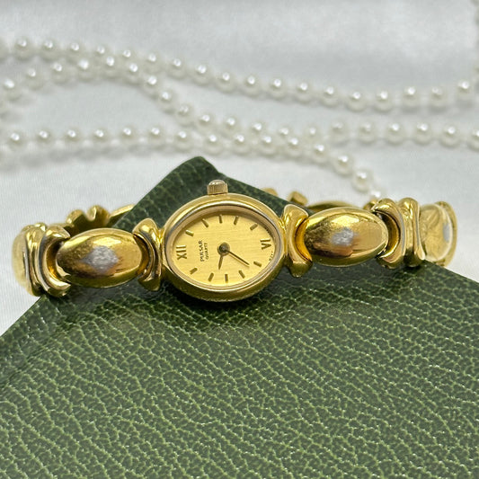 Vintage gold tone Pulsar watch with oval dial, xo "kiss" link band and roman numeral markers from the 1990's.