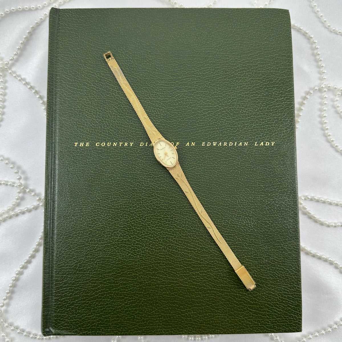 Slender Gold Armitron Watch with Oval Dial and Floral Band