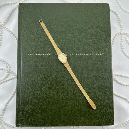 Slender Gold Armitron Watch with Oval Dial and Floral Band