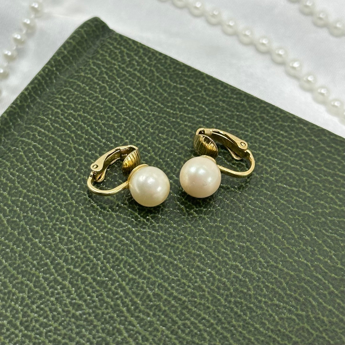 Classic vintage gold tone clip on earrings with simulated pearls.