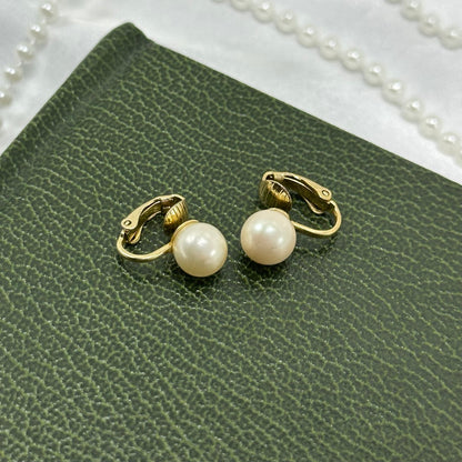 Classic vintage gold tone clip on earrings with simulated pearls.