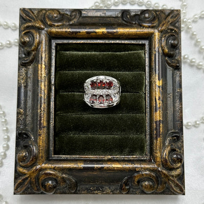 Rhodium plated vintage deadstock cocktail ring with red stones surrounded by a cluster of cubic zirconia stones.