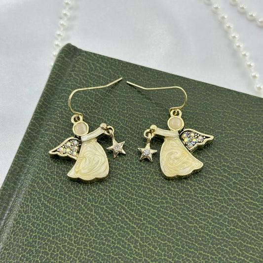 Gold tone KC dangle earrings with enamel angels that have AB stone wings and are holding dangle stars.