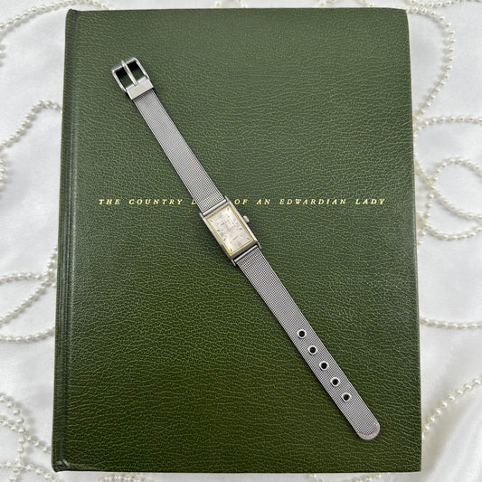 Silver tone watch with rectangular dial and metal strap band.