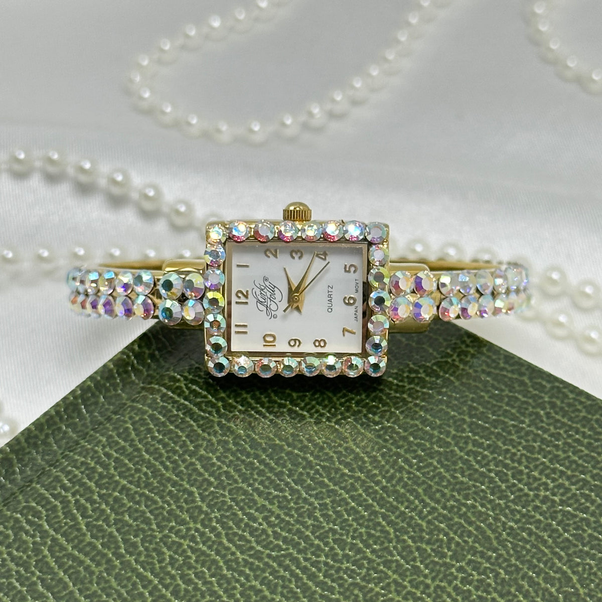 Vintage gold tone Kirks Folly cuff watch with aurora borealis stones and square dial.