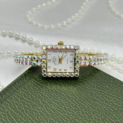 Vintage gold tone Kirks Folly cuff watch with aurora borealis stones and square dial.