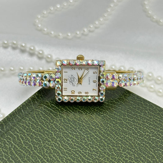 Vintage gold tone Kirks Folly cuff watch with aurora borealis stones and square dial.