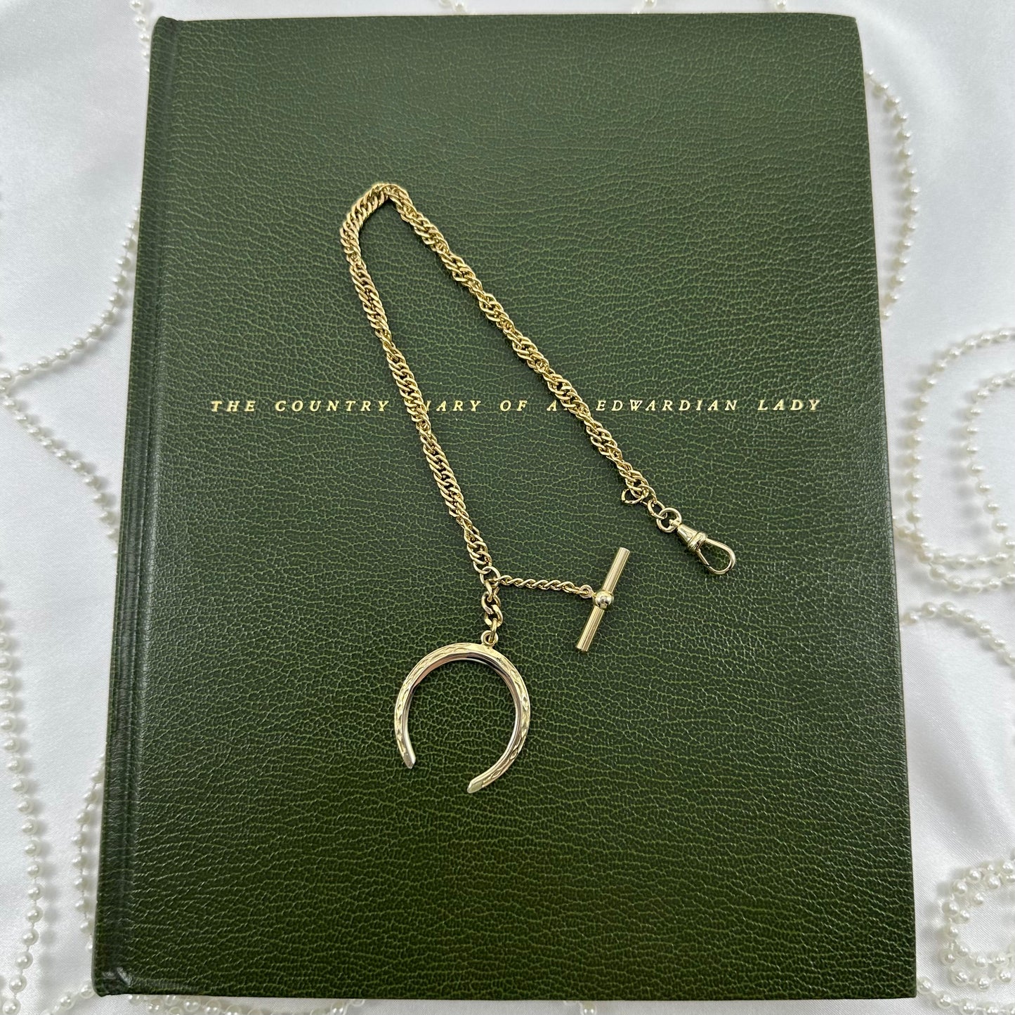 Vintage gold filled twisted metal watch chain with dog clip clasp, t-bar, and moon shaped fob charm from the 1960's.