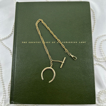 Vintage gold filled twisted metal watch chain with dog clip clasp, t-bar, and moon shaped fob charm from the 1960's.