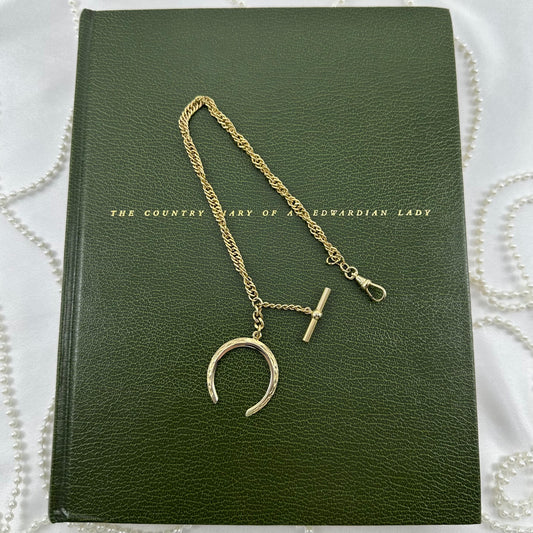 Vintage gold filled twisted metal watch chain with dog clip clasp, t-bar, and moon shaped fob charm from the 1960's.