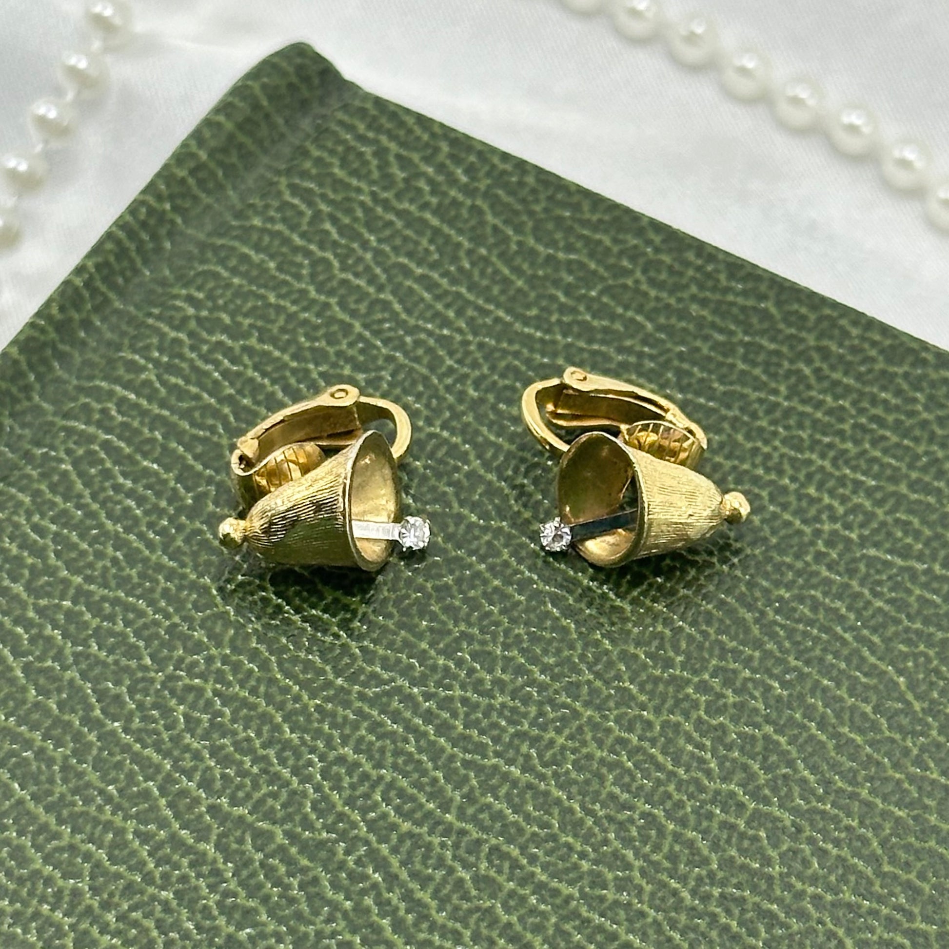 Adorable vintage dainty gold tone clip on Avon earrings with bells and rhinestone clappers that move.