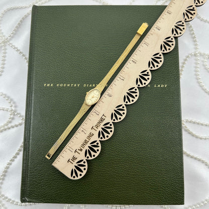 Slender Gold Armitron Watch with Oval Dial and Floral Band