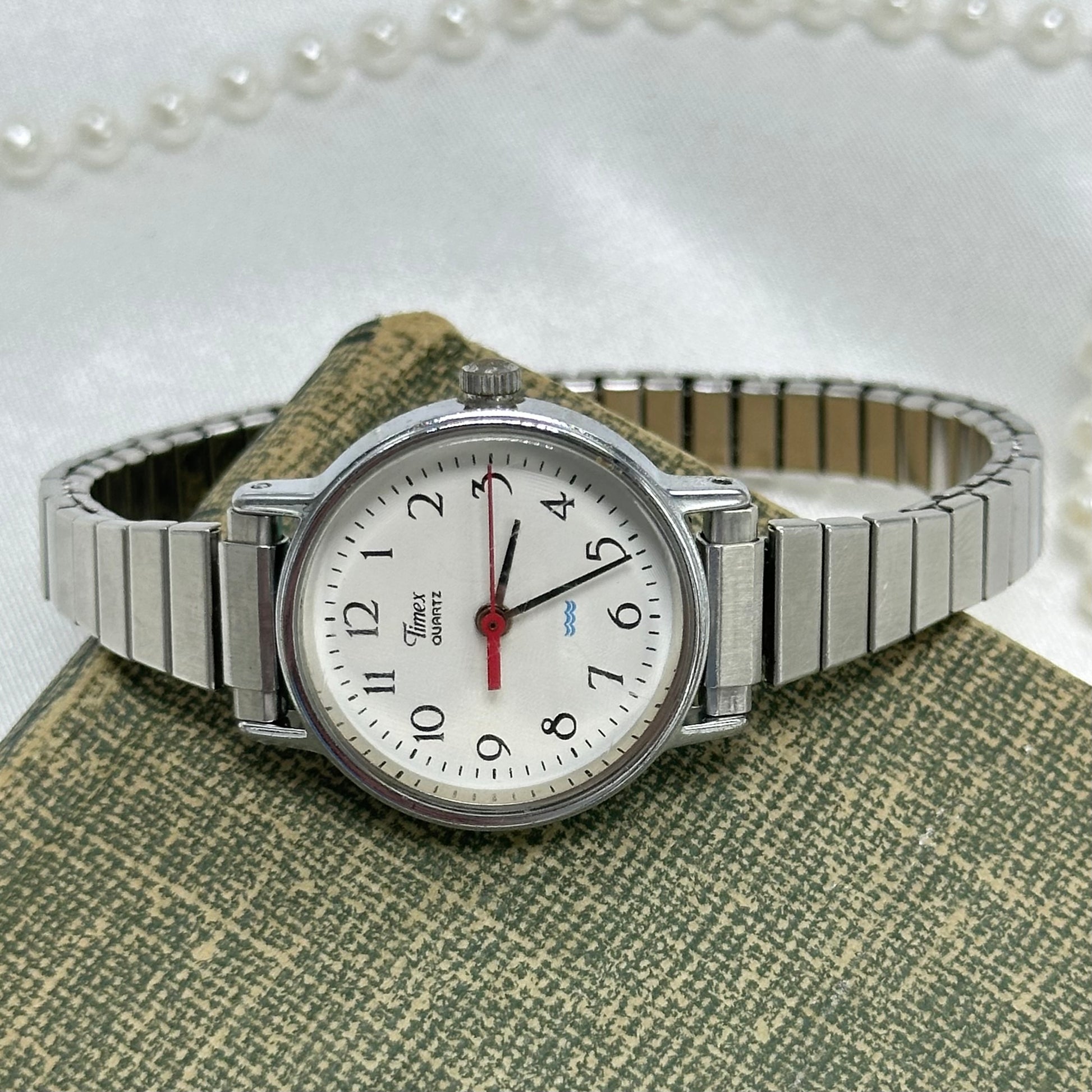Vintage silver tone classic round dial Timex watch with stretchable band and quartz movement. Water resistant.