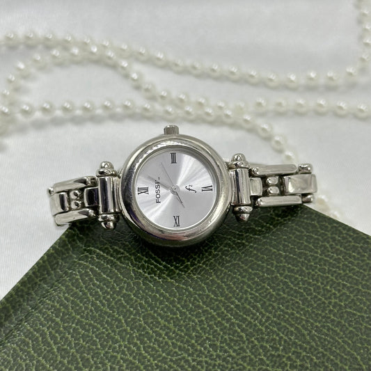 Silver tone Fossil F2 watch with round dial and roman numeral markers.