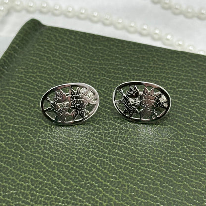 Rare vintage silver tone oval Avon clip on earrings with intricate flower cut out from the 1980's.