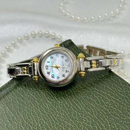 Silver and gold tone Jaclyn Smith watch with round mother of pearl dial and two-tone clasp band.