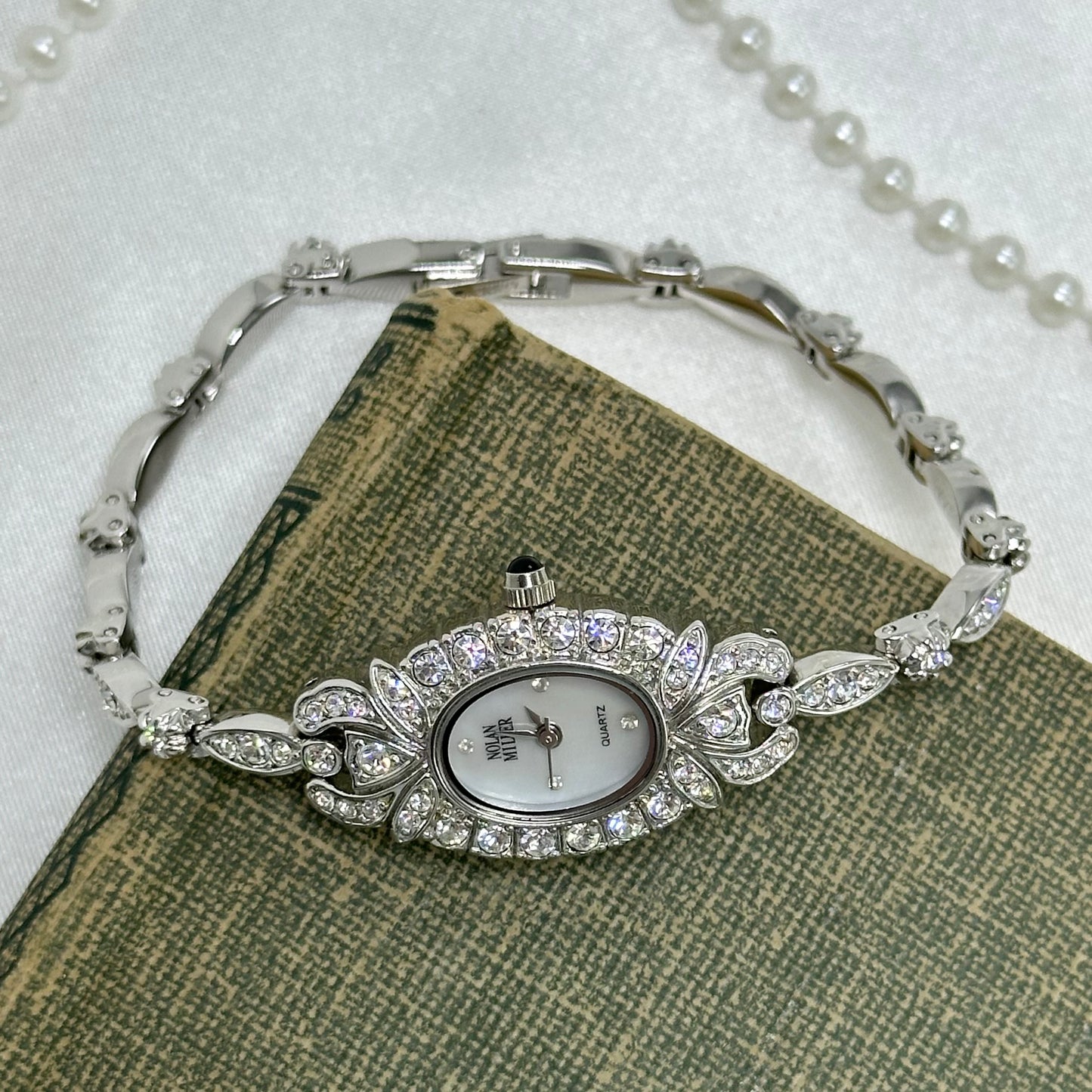 Elegant Crystal Silver Nolan Miller Watch with Mother of Pearl Dial