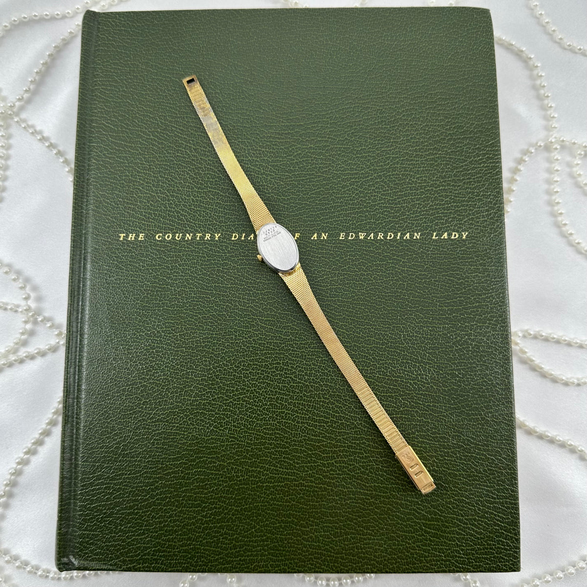Slender Gold Armitron Watch with Oval Dial and Floral Band