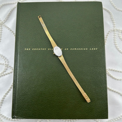 Slender Gold Armitron Watch with Oval Dial and Floral Band