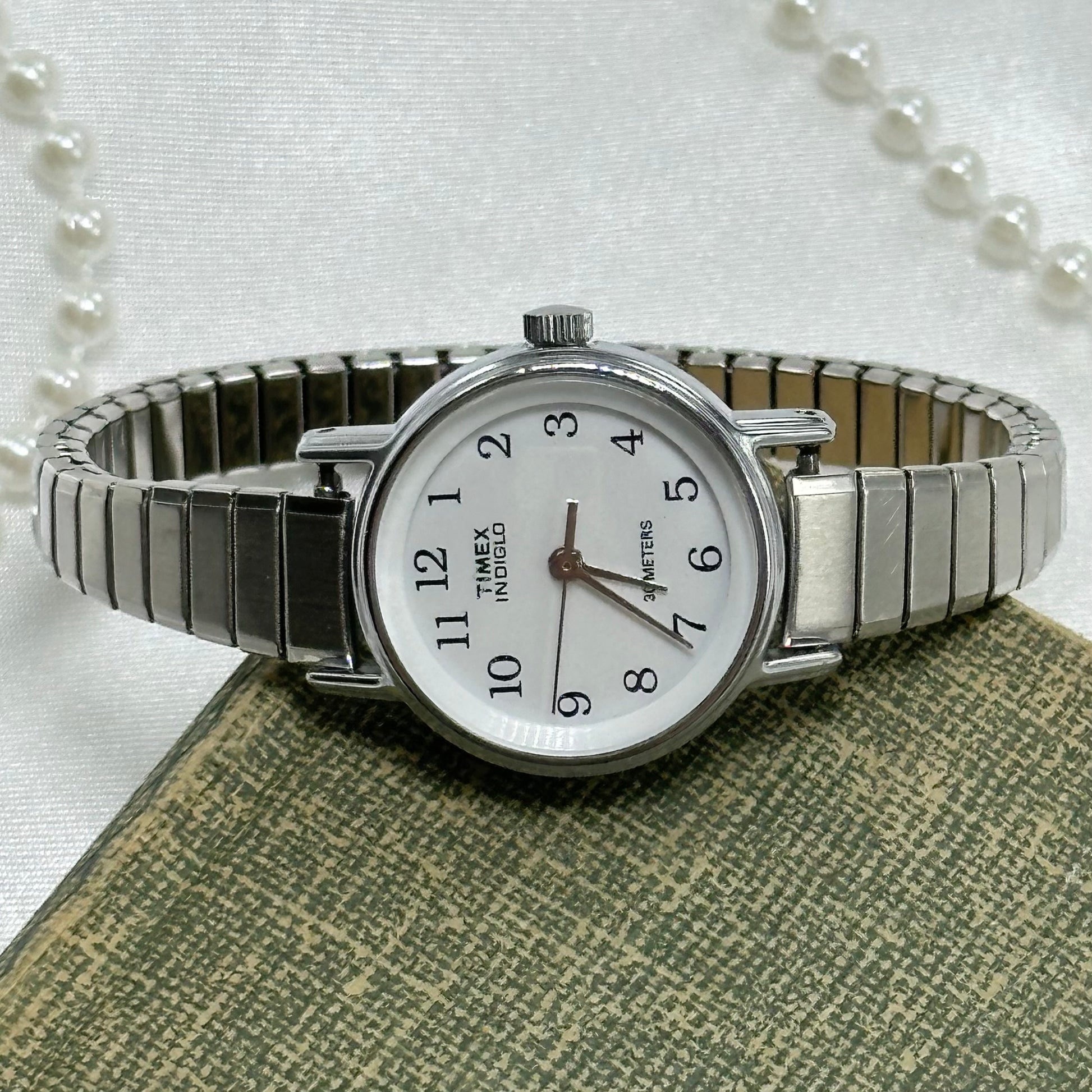 Vintage silver tone water resistant Timex Indigo watch with quartz movement and stretchable band.