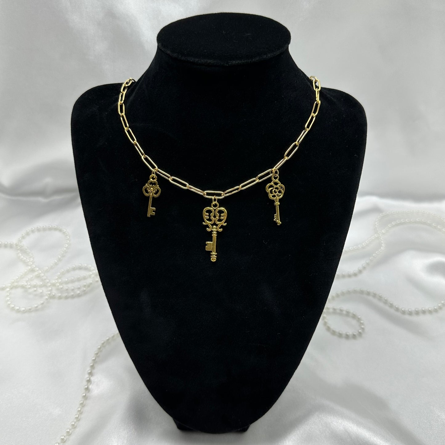 Gold tone paperclip chain necklace with vintage style skeleton key charms. 18K gold plated stainless steel chain.