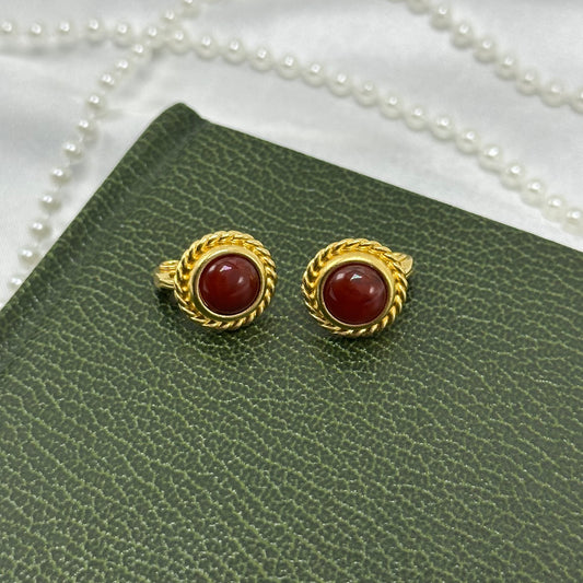 Adorable vintage oval clip on earrings with red stones and braided metal rope frames.