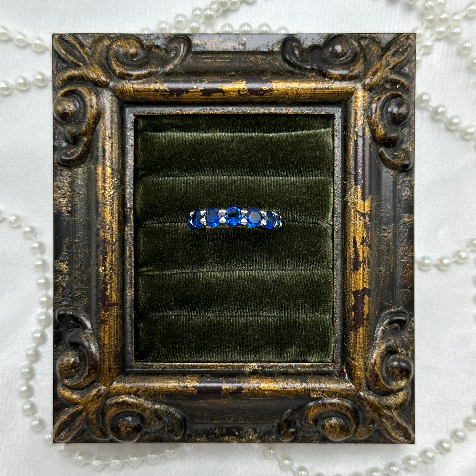 Rhodium plated vintage deadstock infinity band ring with bright blue and clear cubic zirconia stones.