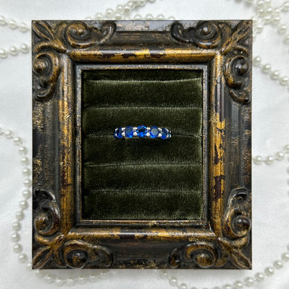 Rhodium plated vintage deadstock infinity band ring with bright blue and clear cubic zirconia stones.