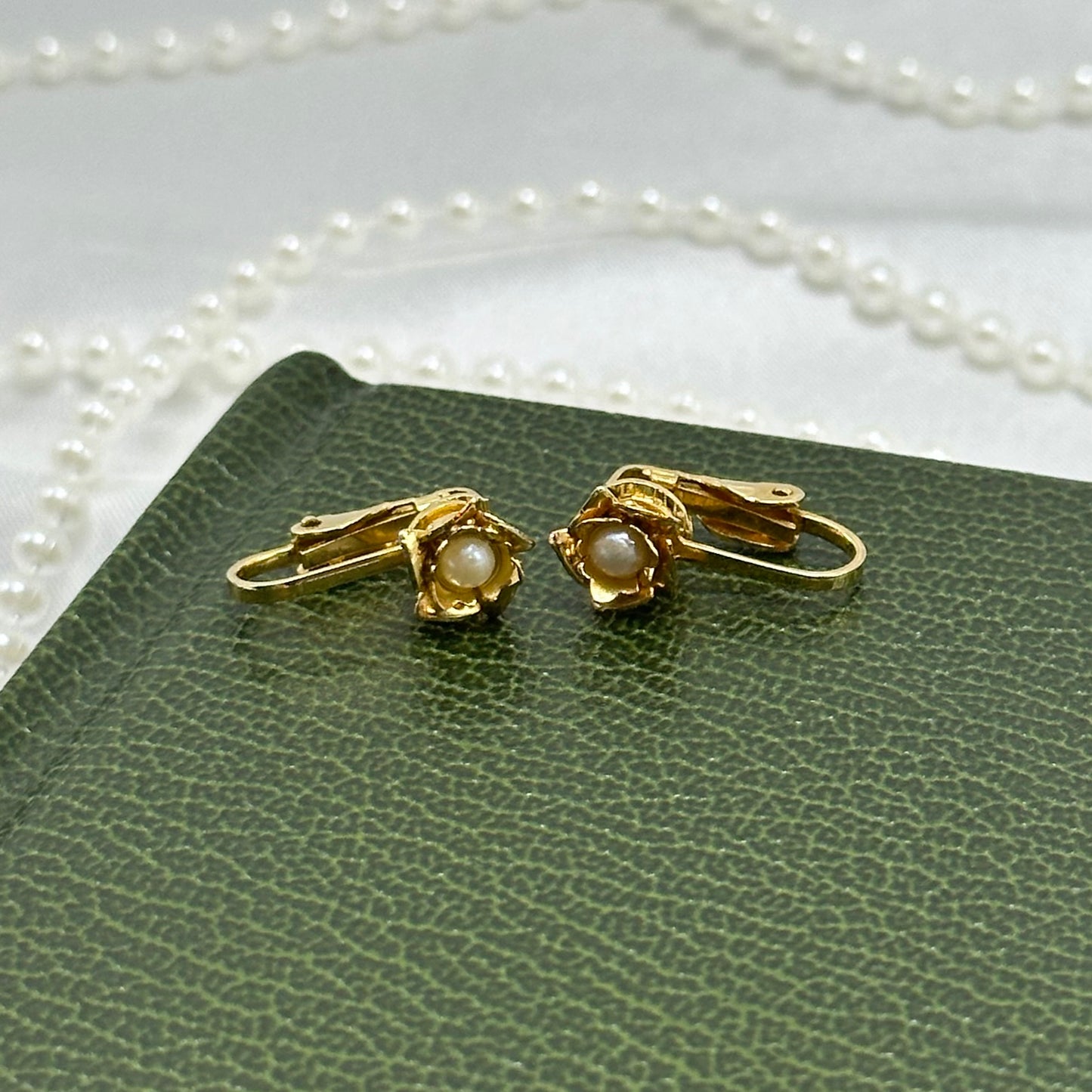 Vintage dainty gold tone clip on flower earrings with faux pearl centers.