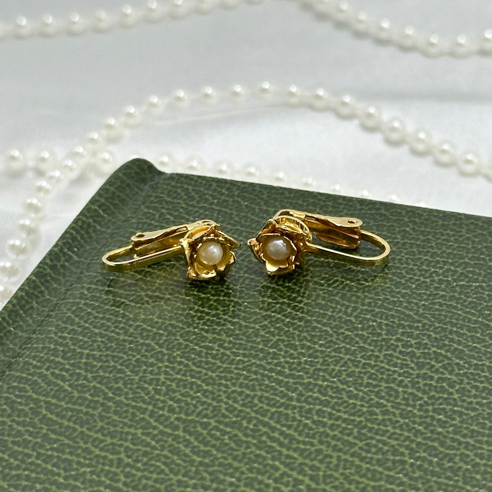 Vintage dainty gold tone clip on flower earrings with faux pearl centers.