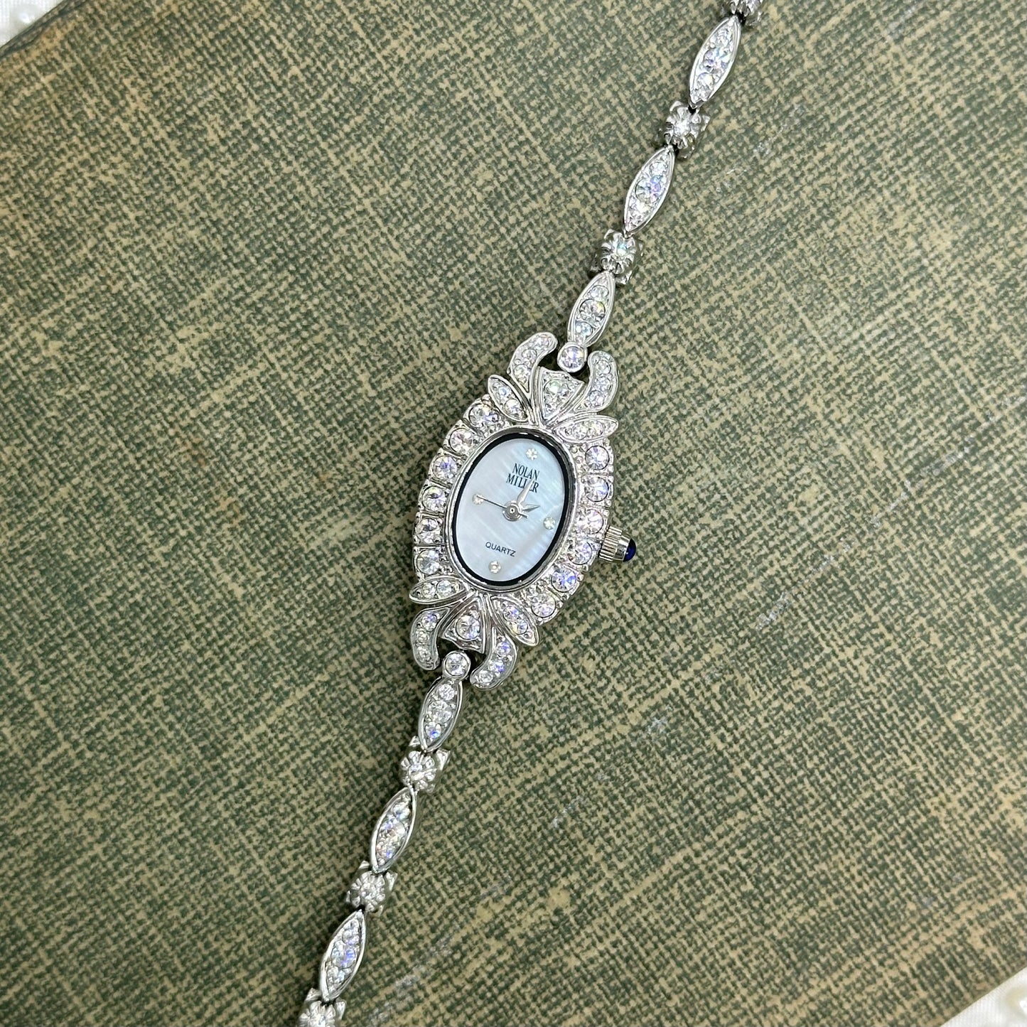 Elegant Crystal Silver Nolan Miller Watch with Mother of Pearl Dial
