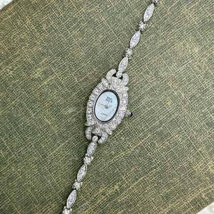 Elegant Crystal Silver Nolan Miller Watch with Mother of Pearl Dial