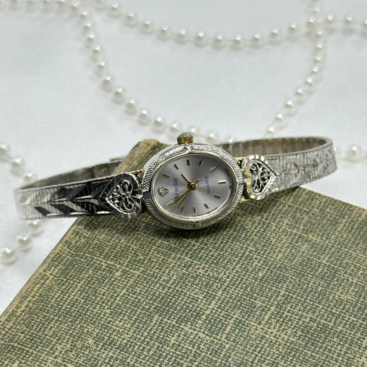 Vintage silver tone heart Westclox watch with gold accents and quartz movement.