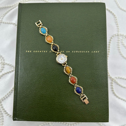 Vintage gold tone multicolor scarab watch with mother of pearl dial and quartz movement.