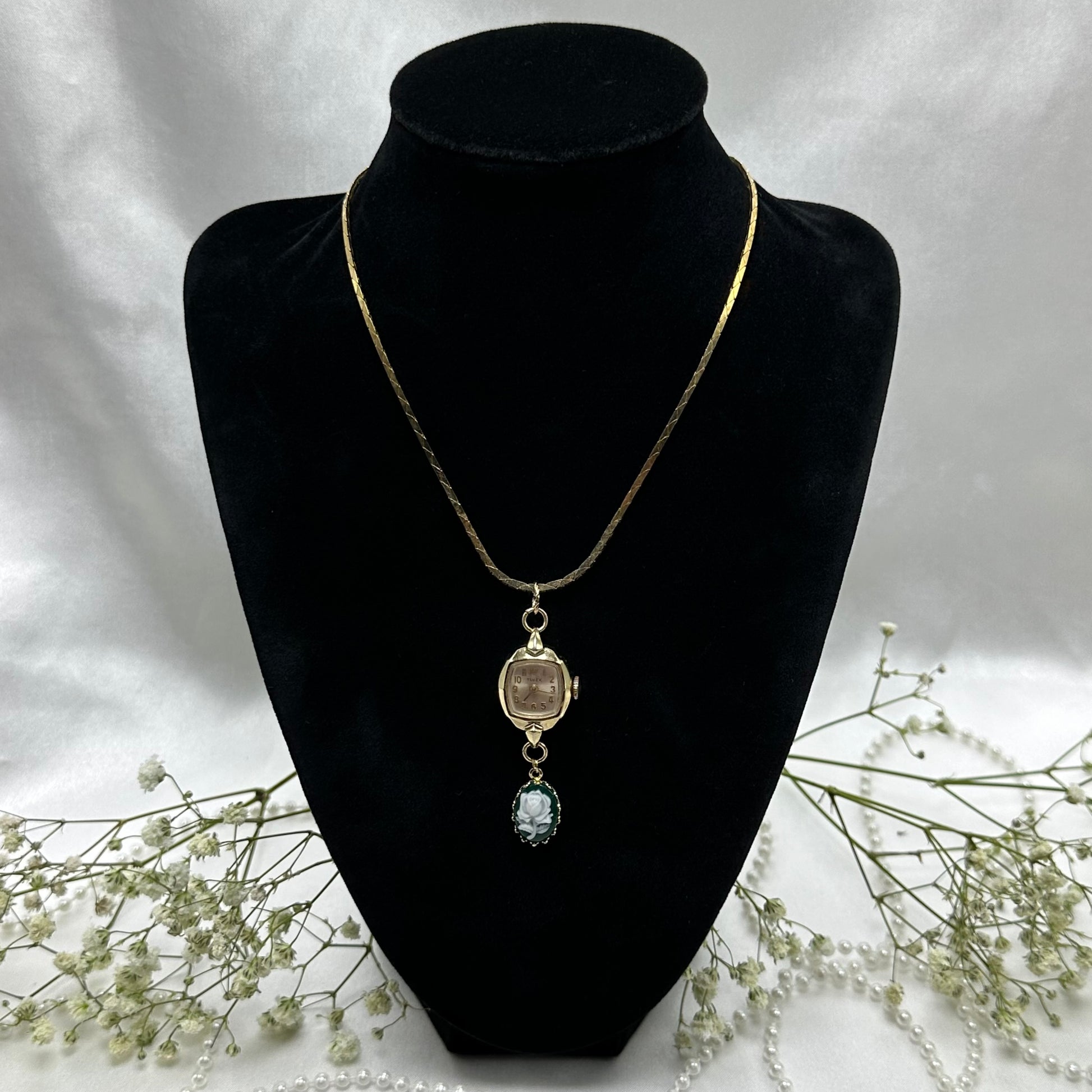 Gold tone necklace with vintage Timex watch and green rose cameo pendant on a cobra link chain.