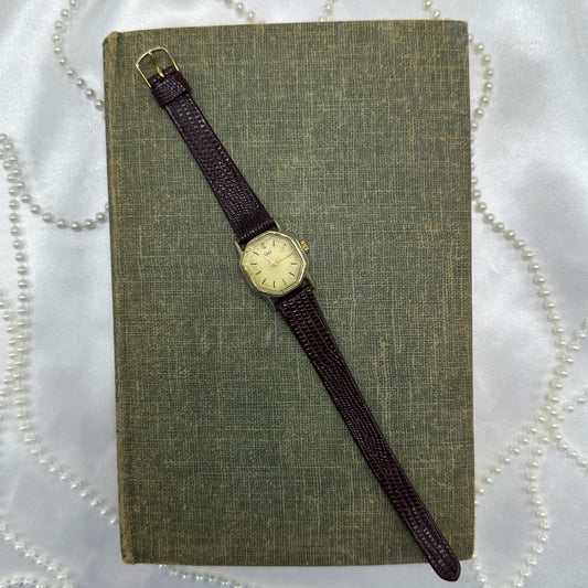 Classic gold tone Q&Q watch with brown leather strap.