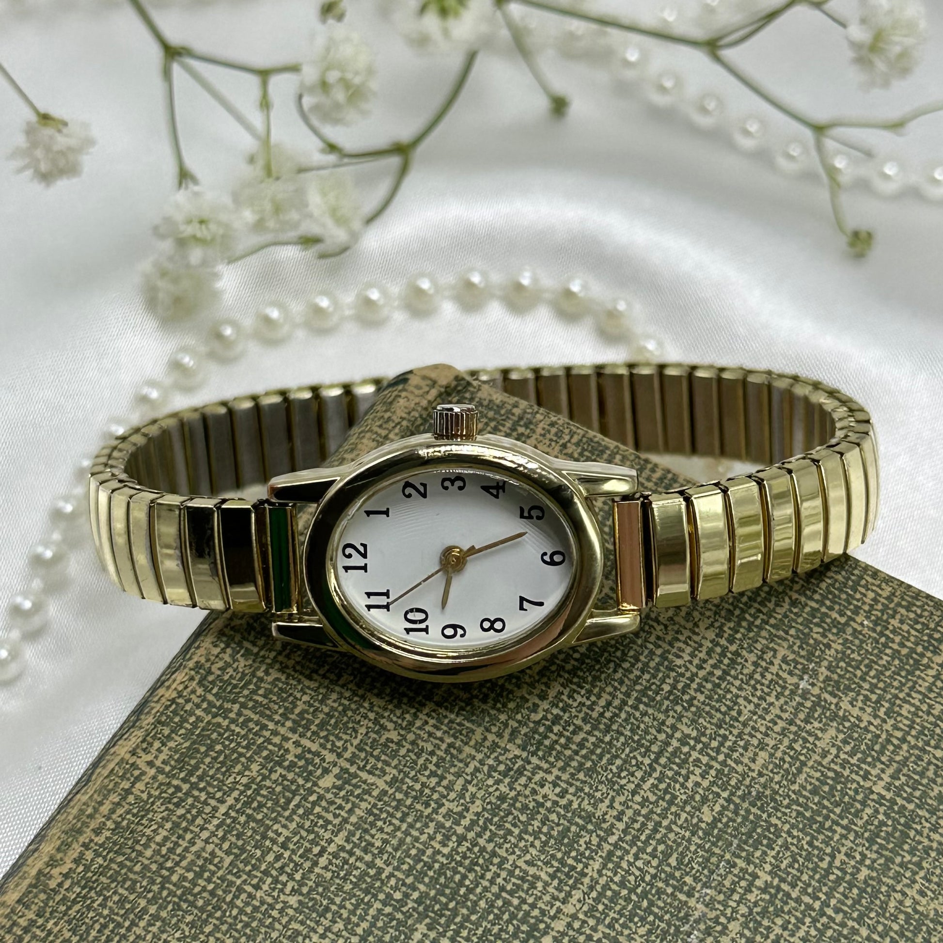 Classic oval dial gold tone watch with stretchable band.