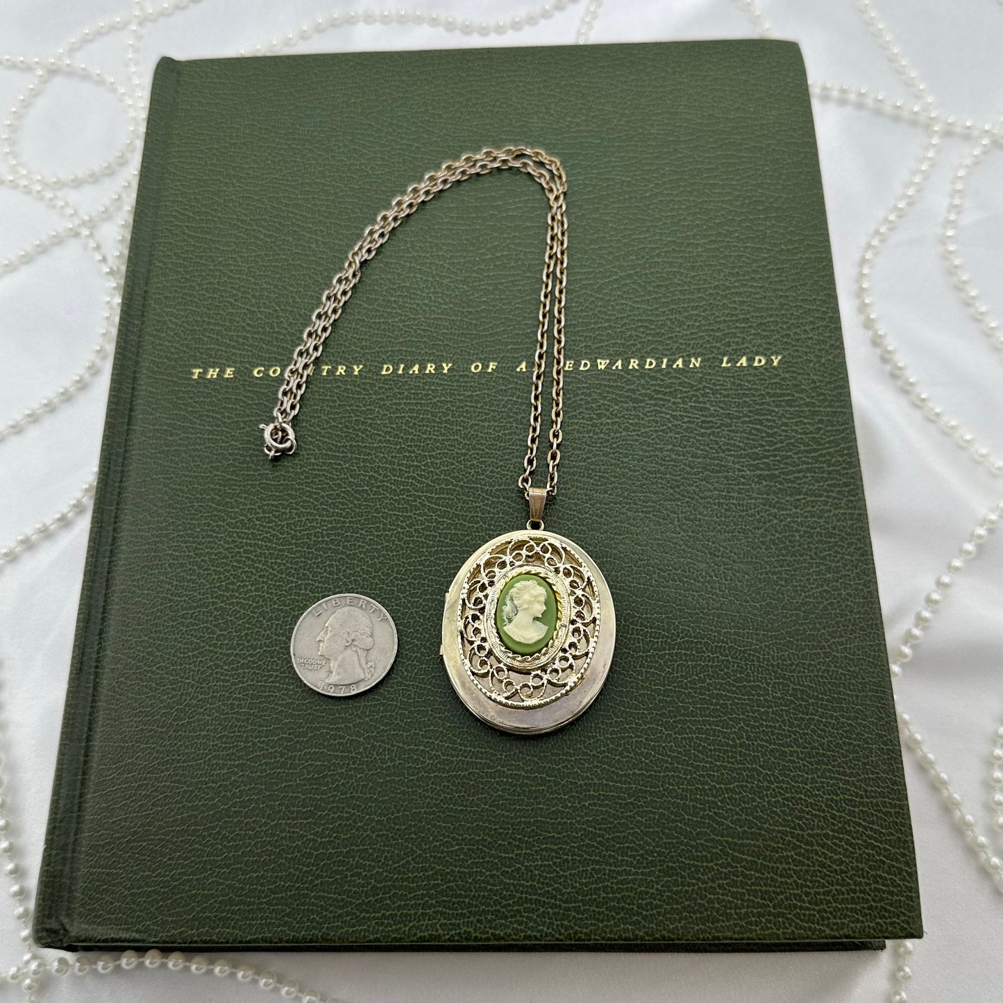 Vintage gold tone filigree locket necklace with green cameo.