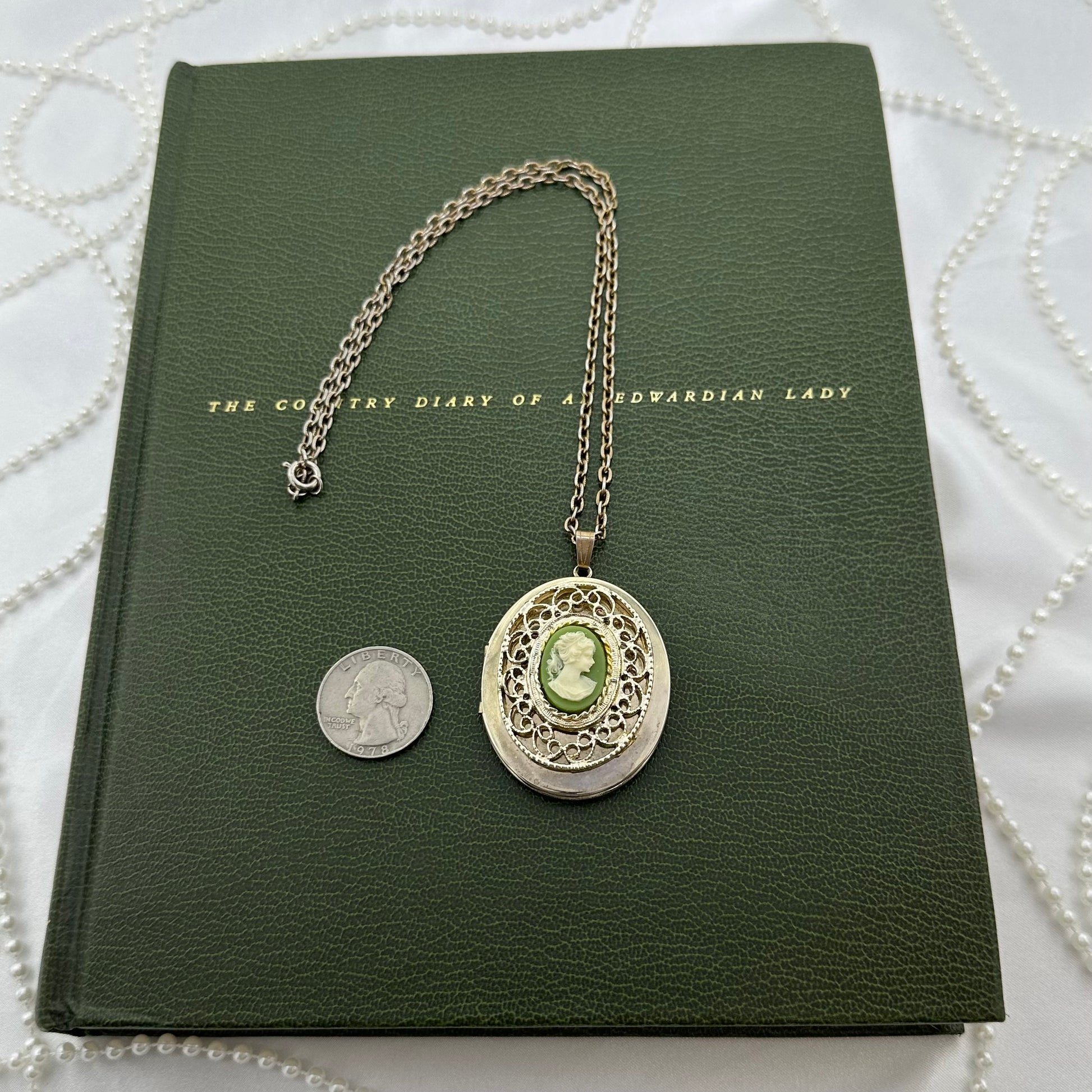 Vintage gold tone filigree locket necklace with green cameo.