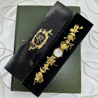 Vintage gold tone rare Kirks Folly charm watch covered in aurora borealis stones with celestial and fantasy charms like moons, stars, and fairies. Comes with original box.