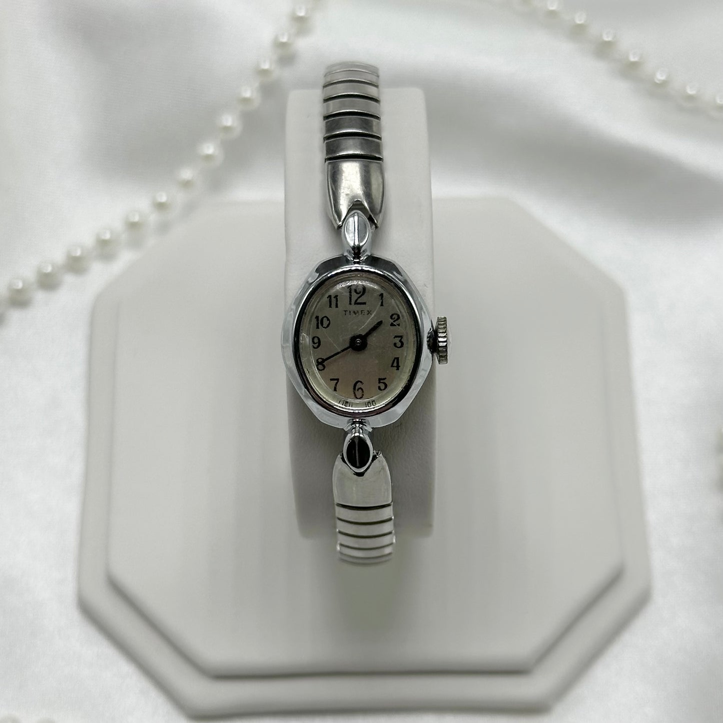 Dainty silver tone Timex manual winding watch with stretchable band.&nbsp;