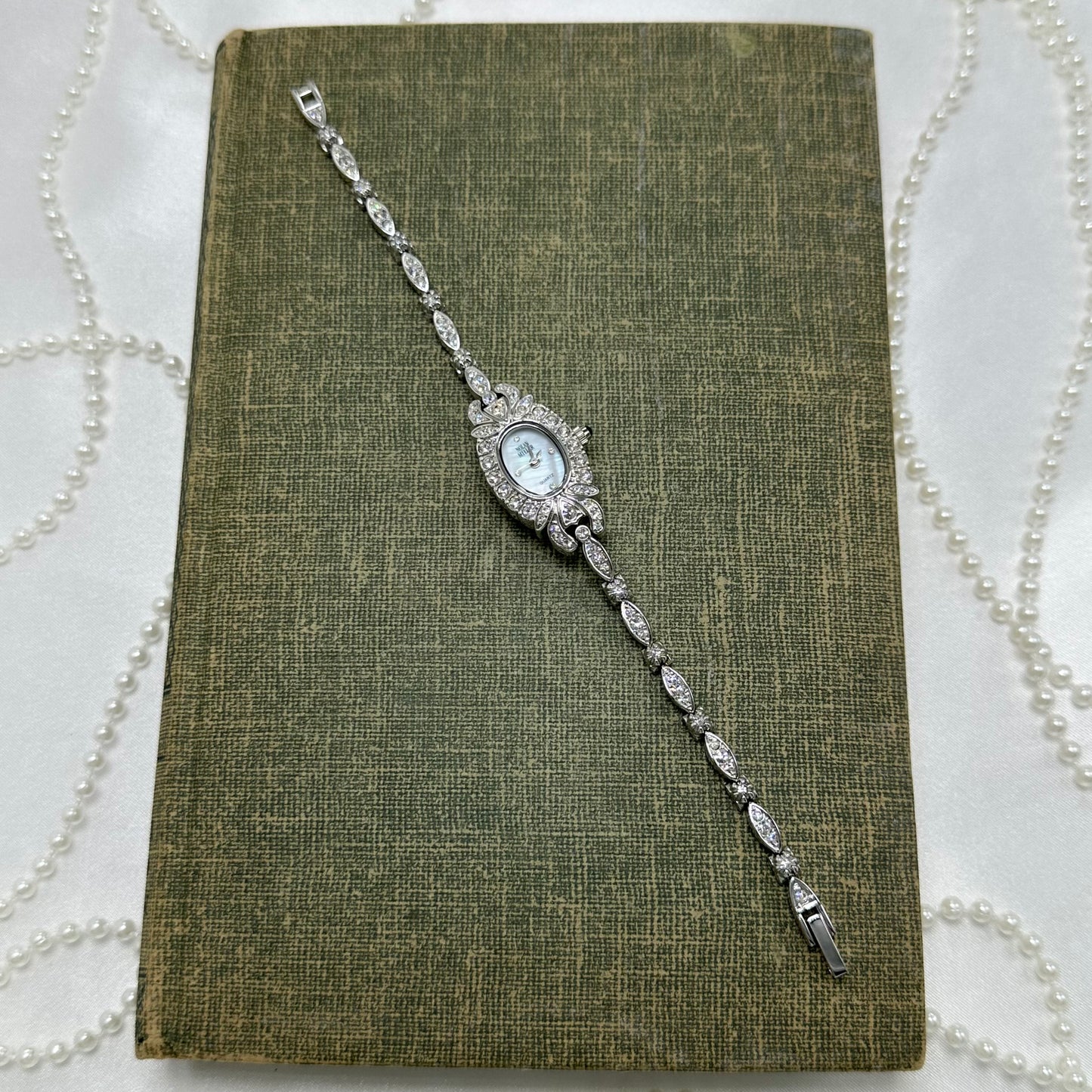 Elegant Crystal Silver Nolan Miller Watch with Mother of Pearl Dial