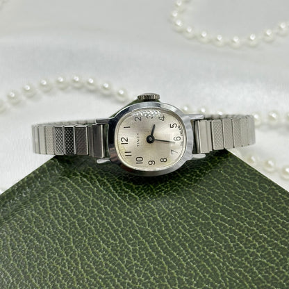 Vintage silver tone Timex manual winding watch with stretchable band.