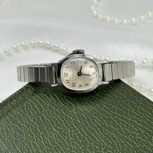 Vintage silver tone Timex manual winding watch with stretchable band.